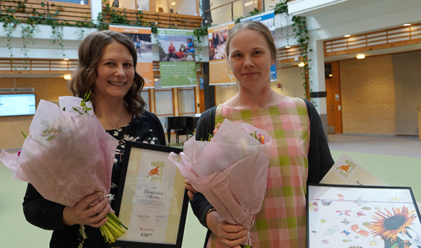 Linda-Marie Häggström och Maria Engelbrektsson med blommar, diplom, tavlor och prischeckar