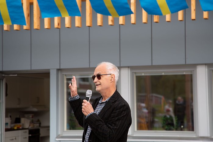 En man i solglasögon håller tal