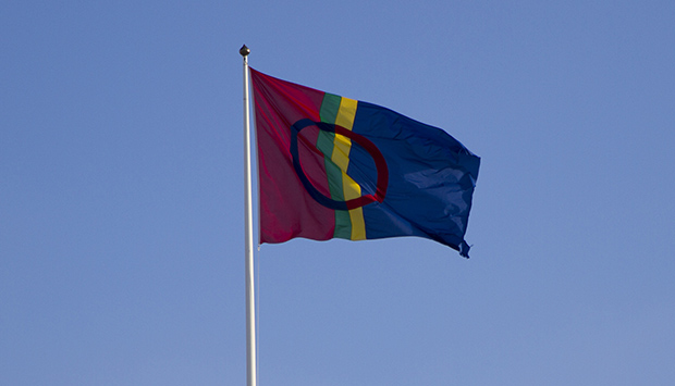 Den samiska flaggan vajar mot en blå himmel