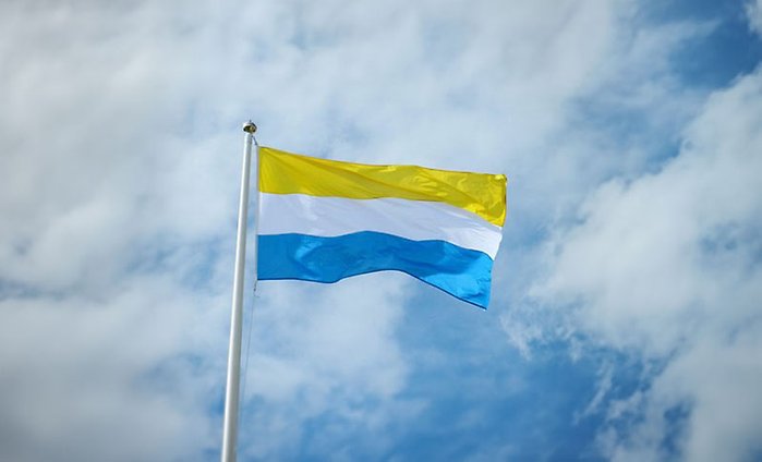 Tornedalingarnas flagga men horisontella ränder i gult, vitt och blått