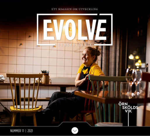 En bild av förstasidan av Evolve, en ljushyad kvinna sitter avslappnat vid ett matbord på en restaurang med blicken bort från kameran och skrattar. Det är halvmörkt och mysigt i lokalen.