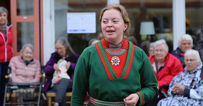 Saara Hermansson jojkar iförd  vacker grön samisk dräkt.